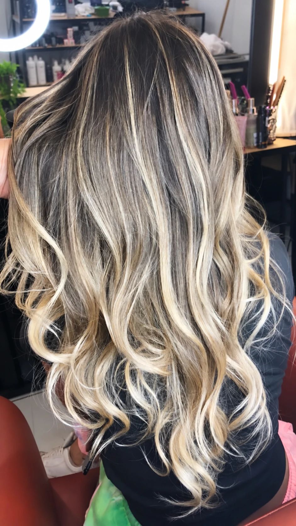 Cabelo loiro longo com mechas claras e ondas definidas, visto de costas