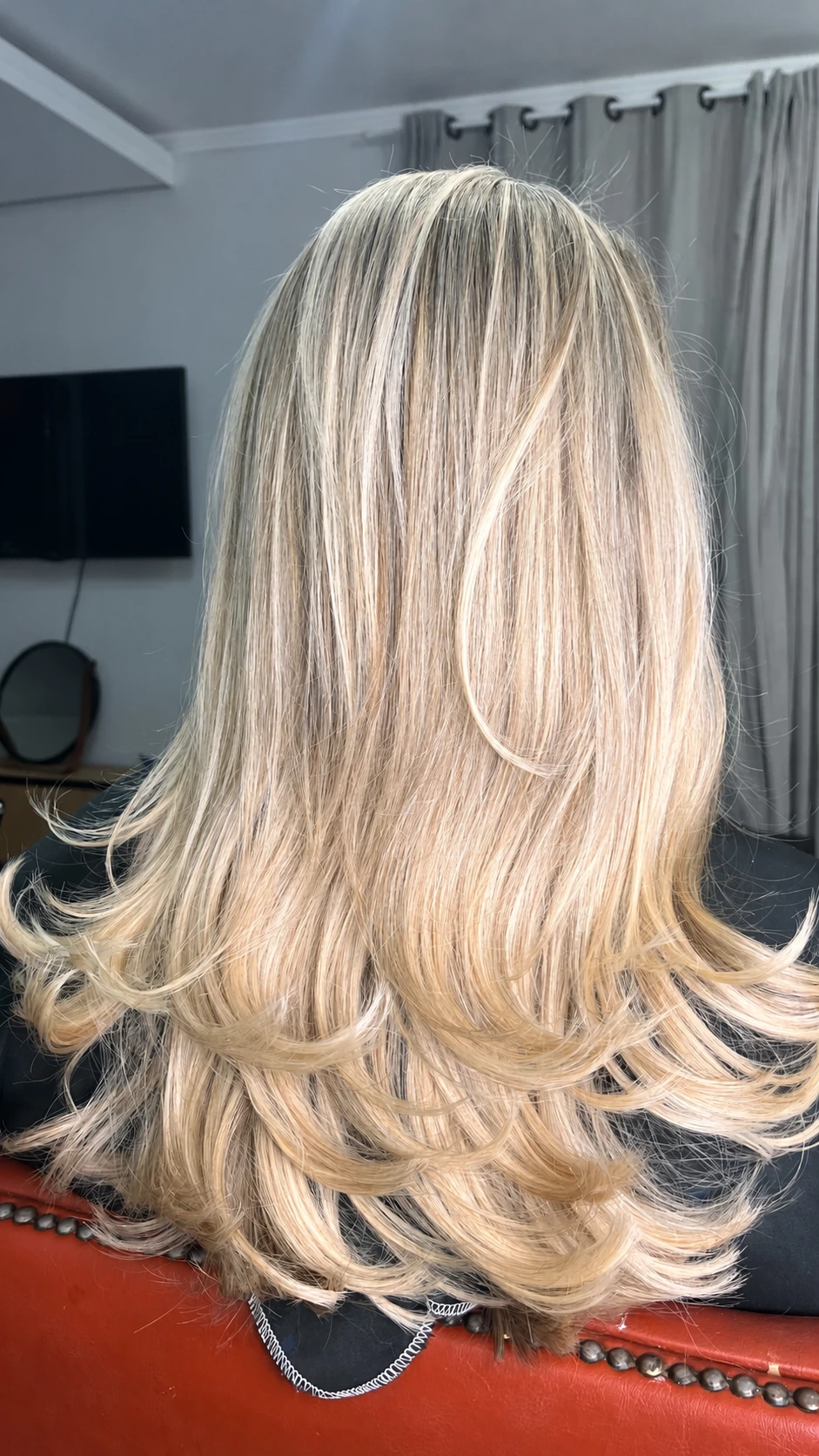 Cabelo loiro claro com pontas modeladas, visto de costas