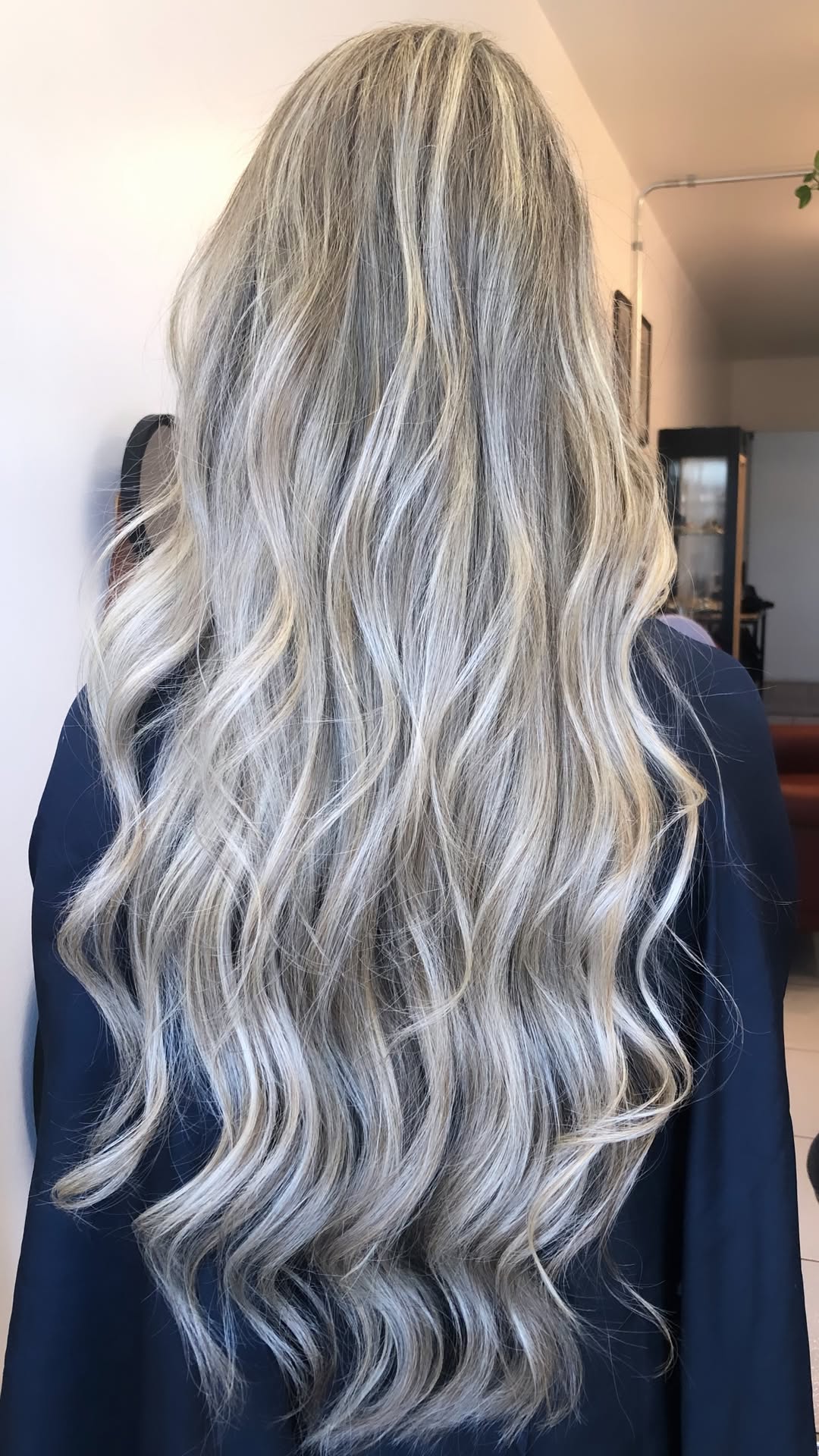 Cabelo loiro longo com ondas e mechas claras, visto de costas