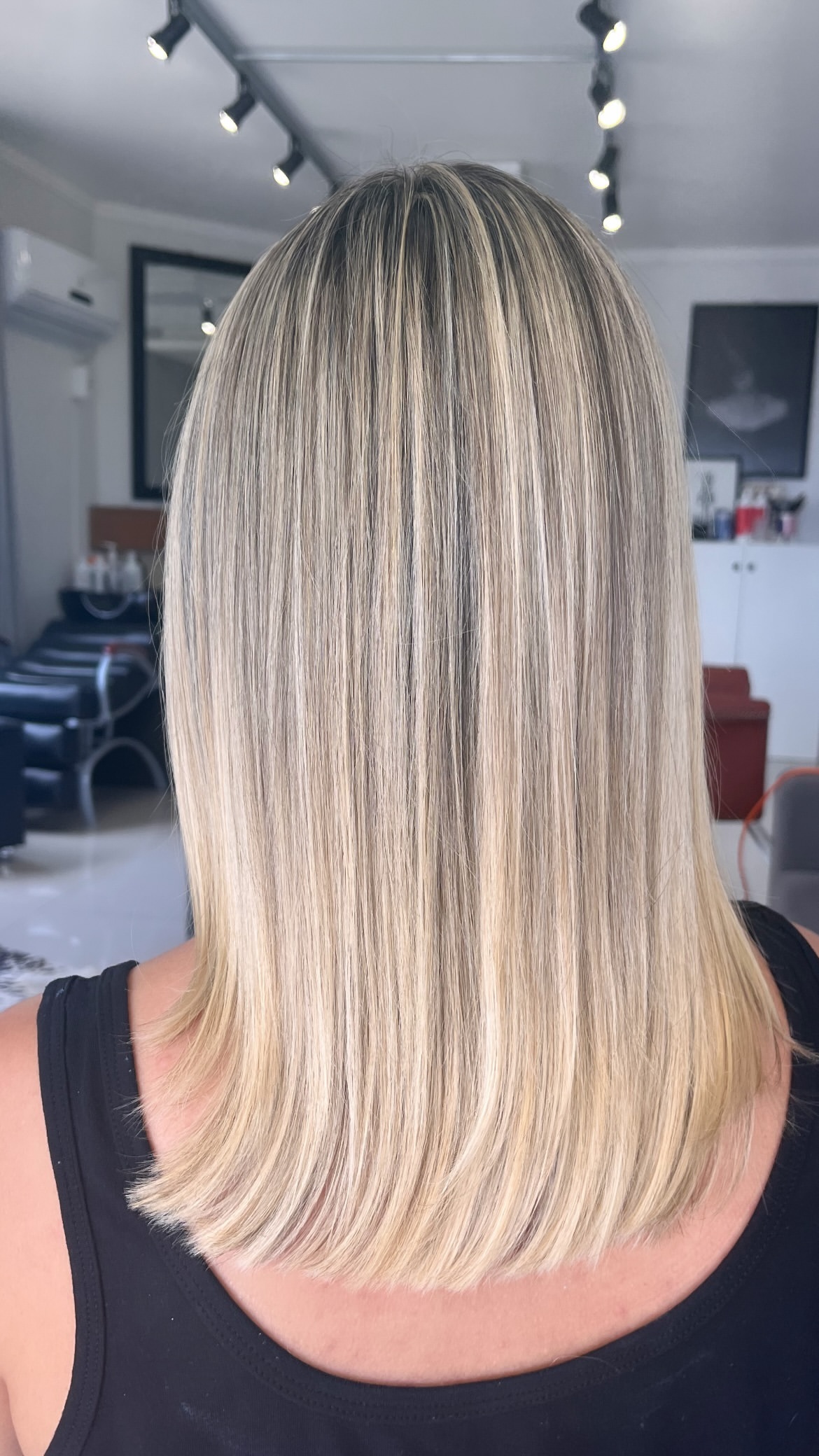 Cabelo loiro médio e liso, visto de costas