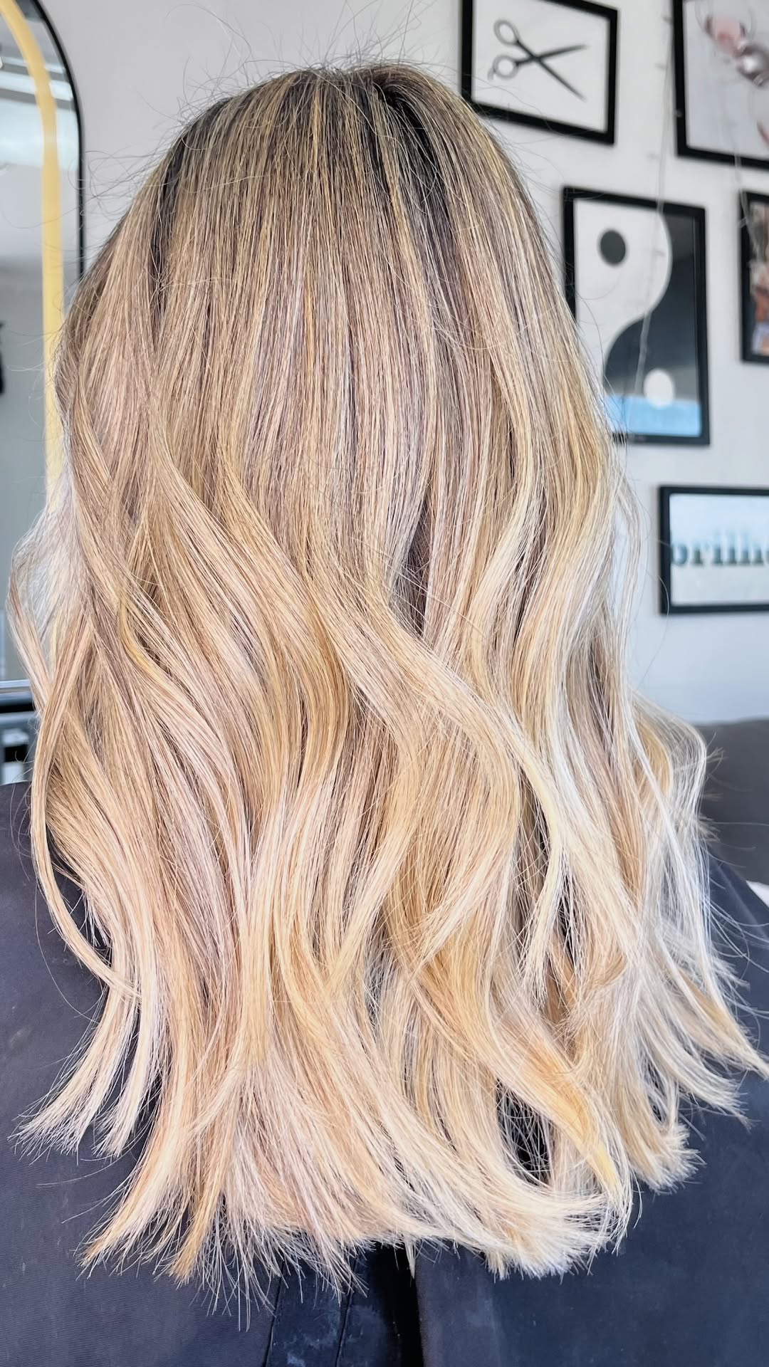 Cabelo loiro ondulado com tons quentes, visto de costas